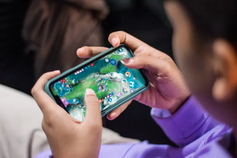 Una persona con un smartphone jugando un videojuego móvil